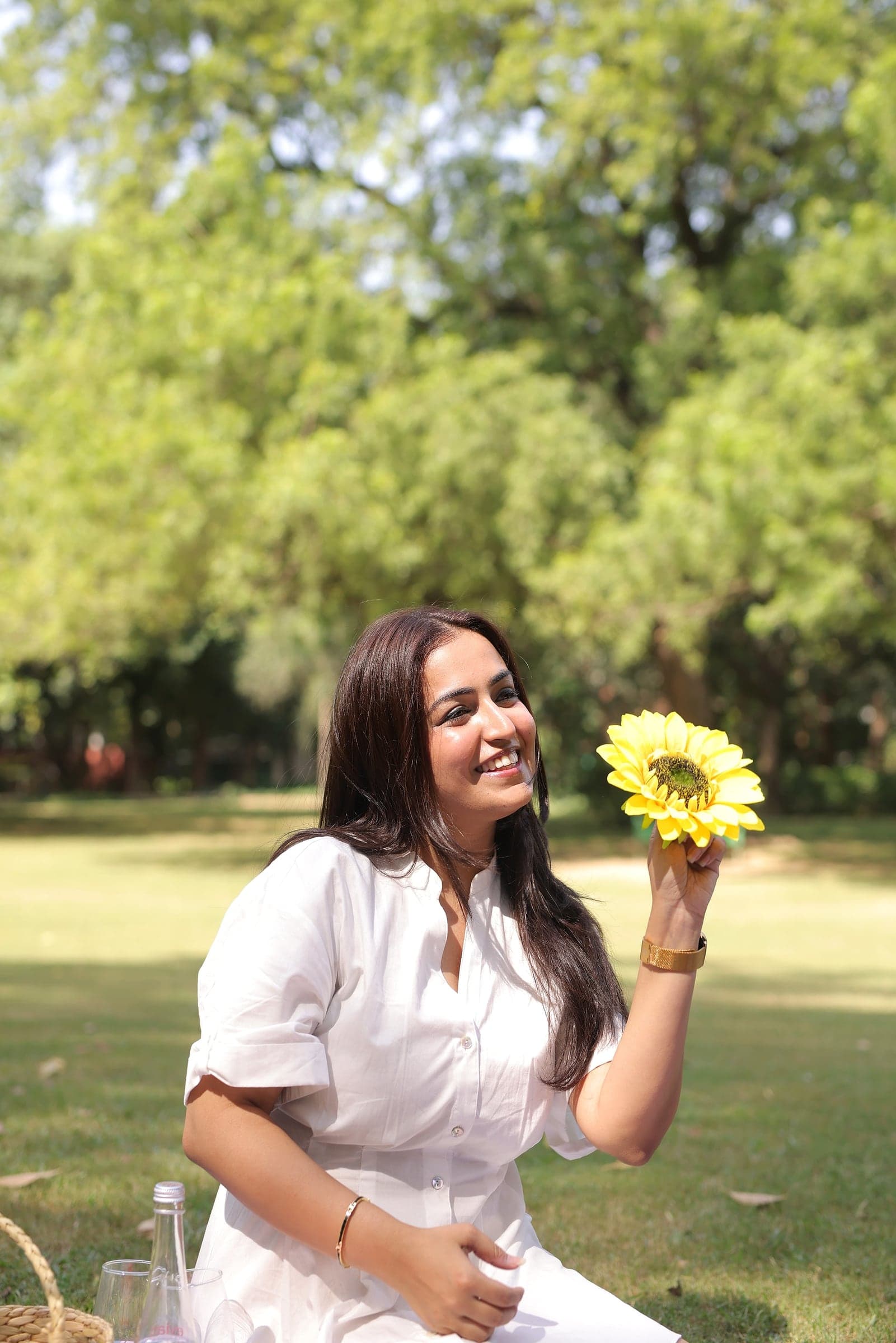 Disha holding a sunflower in a park