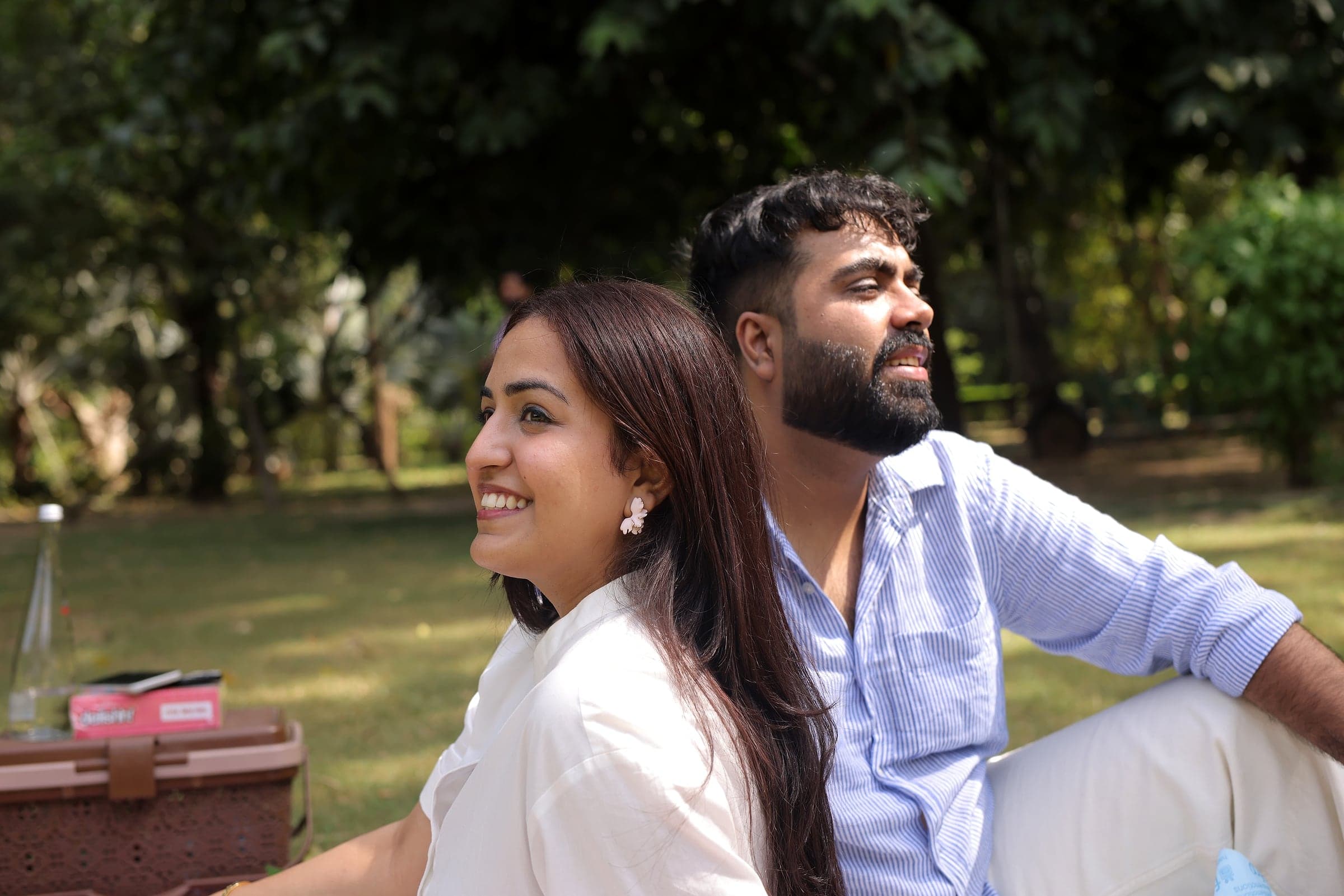 Disha and Mayank sitting on the grass, smiling